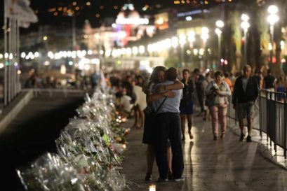 Two people hold each other by the new makeshift memorial on July 18, 2016 in Nice, in tribute to the victims of the deadly Bastille Day attack at the Promenade des Anglais