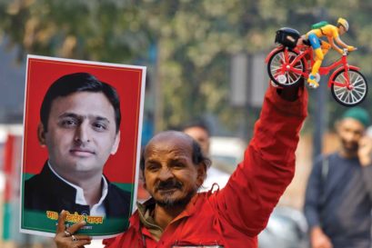 An SP worker in Lucknow holds up a toy bicycle after the Election Commission’s decision to allot the poll symbol to Akhilesh Yadav