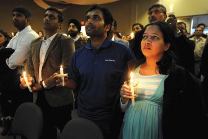 Alok Madasani (in dark blue), who was wounded in the shooting that left Srinivas Kuchibhotla dead, at a candlelight vigil in Olathe, Kansas